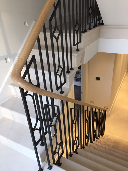 Elegant, continuous steel staircase balustrade with oak handrails