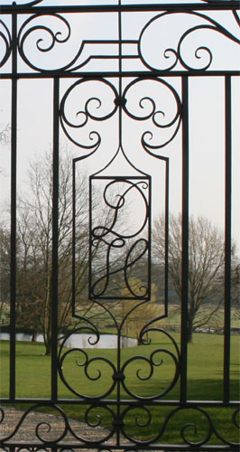 Automatically opening wrought iron gates with monogram detail