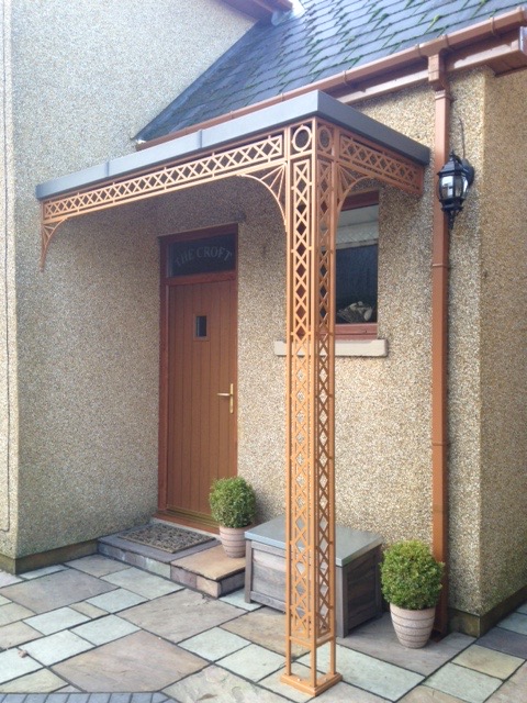 Modern style Contemporary Georgian design Ironwork Corner Porch Awning Covered with a Flat Roof Canopy which is Zinc Galvanised mild steel that is Powder Coated Lead Grey. Finishing touches include Cast Shoe covers and Ironwork Gallows Brackets