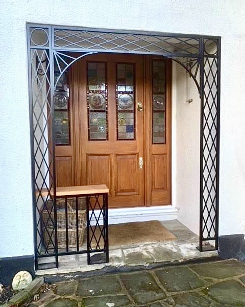 Our Treillage design ironwork was used to enclose this recessed porch including metal fixing plates to bolt down to existing pavers and a small shelf
